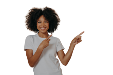 Positive cheerful dark skinned woman pointing at copy space isolated on beige background