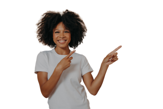 Positive cheerful dark skinned woman pointing at copy space isolated on beige background