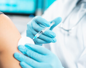 African-American doctor makes a coronavirus vaccine using a syringe and hypodermic needle....