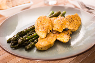 cooked dish. Chicken nuggets with green asparagus on plate