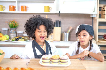 Adorable multiethnic schoolgirls enjoy making baked goods in pastry and bakery class at culinary school.