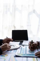 Businessmen meeting using laptop computers calculator stock market chart paper for analysis Quality improvement plan in business idea discussion meeting vertical image