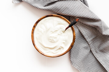 Sour cream or yogurt in wooden bowl. Dairy product background