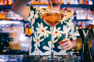 man hand bartender making cocktail in glass on the bar counter