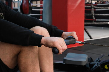 
February 21, 2023 Ukraine, Dnipro. Rowing machine firm Concept 2.
A man on a workout in the gym with his own weight. aeromagnetic simulator. Scandinavian traction for strength work of the back muscle