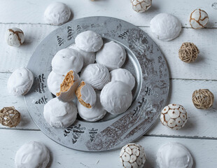 Christmas gingerbread cookies with egg white icing on a silver plate on white background with decoration