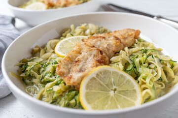 Low carb fish fillet with creamy zucchi noodles on a plate