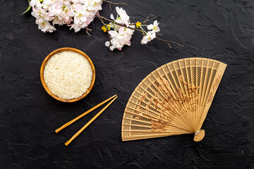 Chinese or Japanese background with bowl of rice and fan, top view