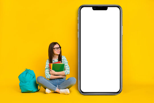 Photo of sitting female college student with homework materials look white banner placard isolated on yellow color background