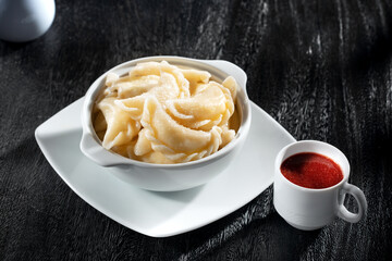 close up view of plate with dumplings  on  dark background.