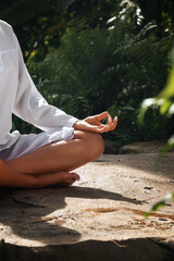 Fragment like image of young woman practicing yoga in tropic environment - 574336185