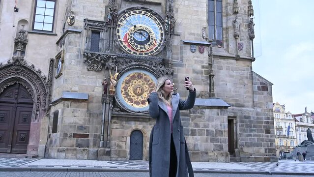 blonde woman near the famous clock in Prague, Czech Republic
