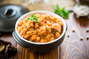 beans stewed with vegetables and spices, in a bowl .