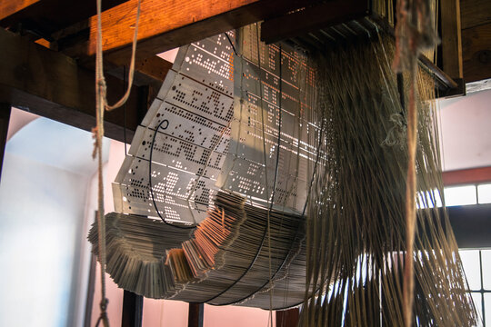 Old jacquard machine, looms for jacquard weaves, enabling to manufacture complex patterns and outstanding linen damasks. Jacquard loom punch card. The revolutionary Vincenzi looms.