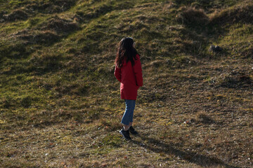 Fototapeta premium A girl enjoying the sunset, dancing around on the hill
