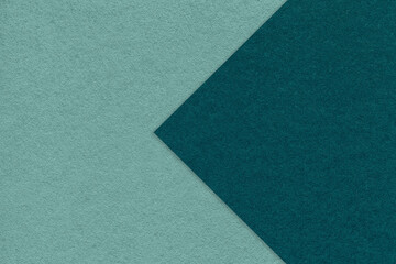 Fototapeta na wymiar Texture of cyan paper background, half two colors with emerald arrow, macro. Structure of dense craft teal cardboard