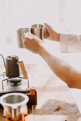 Professional barista preparing coffee using chemex pour over coffee maker and drip kettle. Alternative ways of brewing coffee. Coffee shop concept.