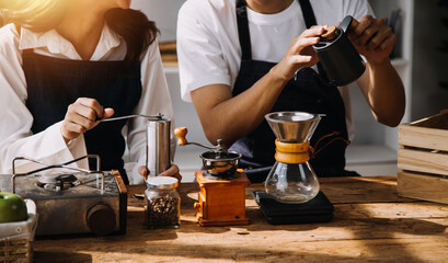 Professional barista preparing coffee using chemex pour over coffee maker and drip kettle. Alternative ways of brewing coffee. Coffee shop concept.