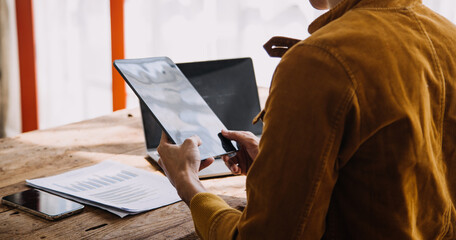 Obraz premium Entrepreneur Asian businessman and businesswoman discussing new business project in tablet in modern Meeting In Modern Office, Asian business casual concept.