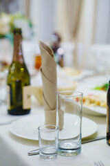 empty glasses and a plate with a cloth napkin on the table. 