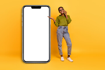 Fototapeta na wymiar Full length body size view of beautiful trendy cheerful girl talking on phone copy space ad isolated over bright yellow color background