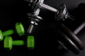 different dumbbells on a black background