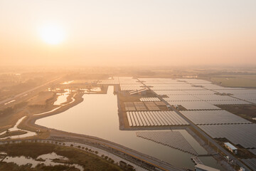 Fototapeta premium Solar Photovoltaic of solar farm aerial view, solar plant rows array of on the water mount system Installation in earthen pond, Floating solar or floating photovoltaics (FPV). Morning scene,