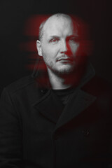 Lifestyle concept. Man with black coat studio portrait. Model with beard looking at camera with serious look. Red color split effect style. 3D glitch virtual reality effect