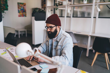 Focused man working on laptop in creative office