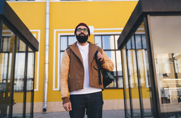 Stylish man standing on street with backpack