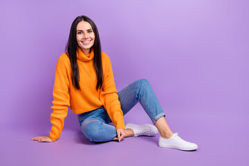 Full length photo of lovely pretty lady sitting floor near empty space promotes new collection clothes isolated on purple color background