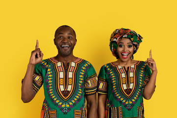 Obraz premium Loving black man and woman in african clothing pointing up