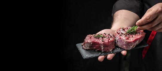 Obraz na płótnie Canvas Beef medallions with rosemary and spices, Raw beef meat steak Tenderloin fillet on a dark background. banner, menu, recipe place for text, top view