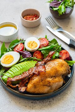 Plate with baked chicken fillet with bacon, fresh vegetables, salad. Popular keto diet, concept of healthy body, food.