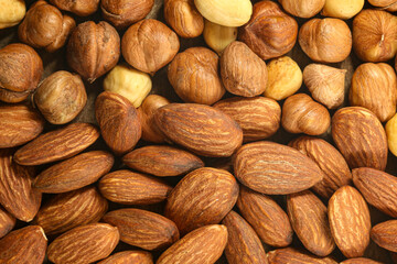 Top view of raw and peeled roasted brown hazelnuts and almonds