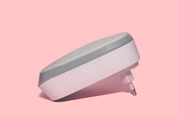 White electric air freshener. Socket. On a pink background.