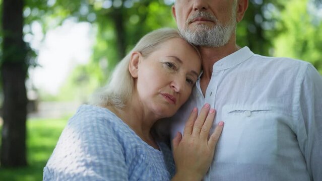 Portrait of unhappy woman hugging her husband, family problems, uncertain future