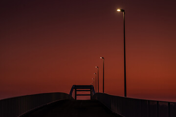 czerwony wschód słońca z mostem i drogą z latarniami - obrazy, fototapety, plakaty