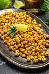 Roasted spicy chickpea or Indian chana or chole with lime. Tasty vegetarian and vegan chickpea snack. Food recipe background. Close up