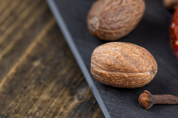 A whole nutmeg on a black stone serving board