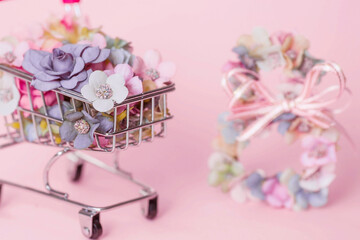 International Women's Day. Banner, flyer, beautiful postcard for March 8. Flowers in the shape of the number eight and a grocery cart on a pink background. Buying a flower by March 8.