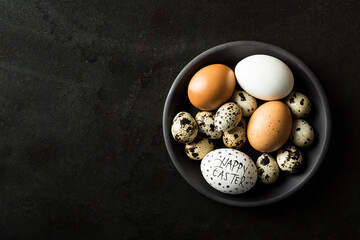 Eggs in a bowl on rustic black metal background