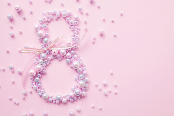 International Women's Day. Banner, flyer, beautiful postcard for March 8. Pearls in the shape of the number eight on a pink background.