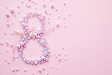 International Women's Day. Banner, flyer, beautiful postcard for March 8. Pearls in the shape of the number eight on a pink background.