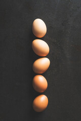 Color gradient eggs lined up in a row on black background