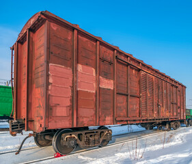 Red old, worn out boxcar of standard design on the rails on Trans-Siberian Railway.