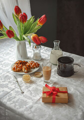Obraz na płótnie Canvas Breakfast on the table with tulips by the window.