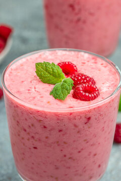 Yogurt smoothie with raspberries in glass on light table. weight loss concept. vertical image. place for text