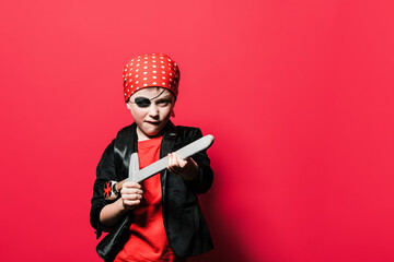 Funny boy in pirate outfit playing with sword