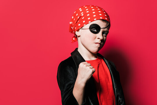 Confident boy in pirate outfit showing fist